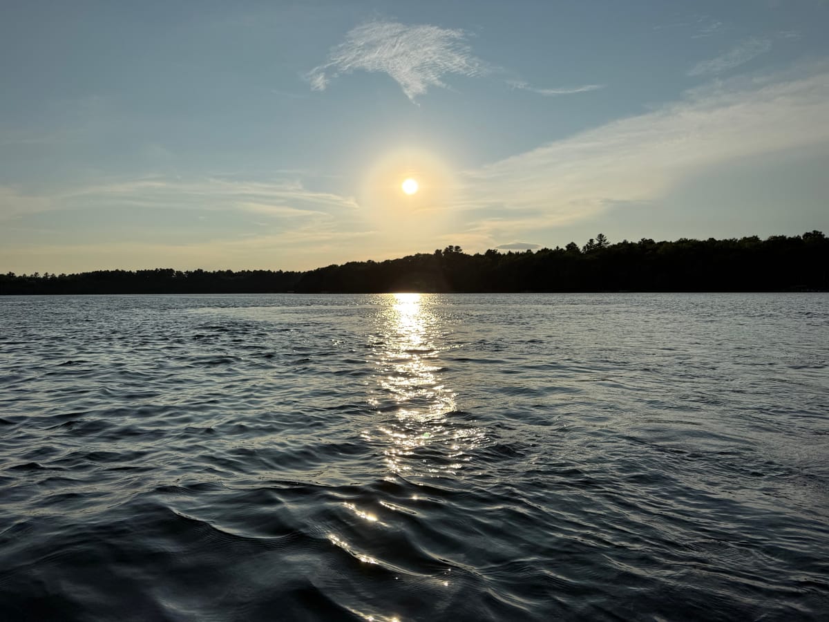 Late afternoon sun over Slim Lake, scattering a bright path across wind-textured water